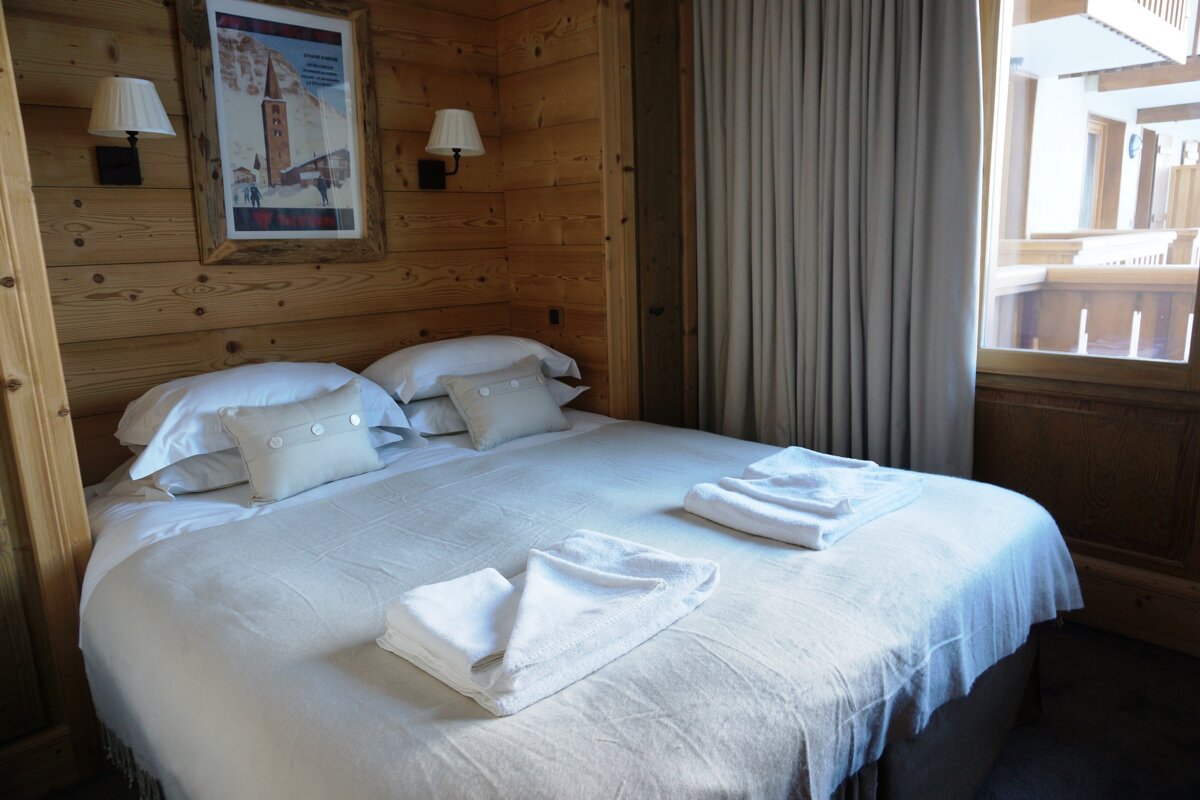 A bedroom with a bed and a picture on the wall