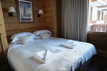 A bedroom with a bed and a picture on the wall