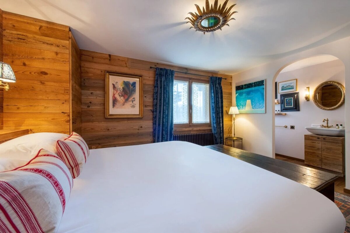 A bedroom with a large bed and a mirror on the ceiling