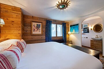 A bedroom with a large bed and a mirror on the ceiling