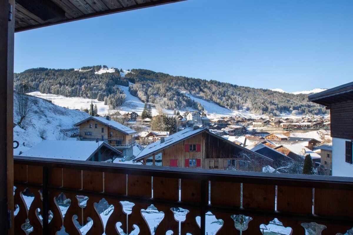 A view of a snowy mountain village from a balcony