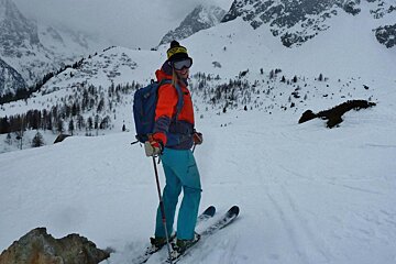 a female skier with mountains in the background
