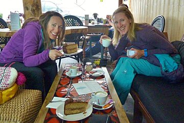 2 females in a coffee shop with cake