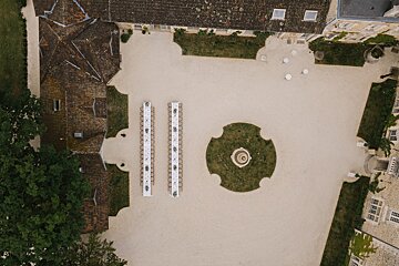An aerial view of a courtyard with tables and a fountain