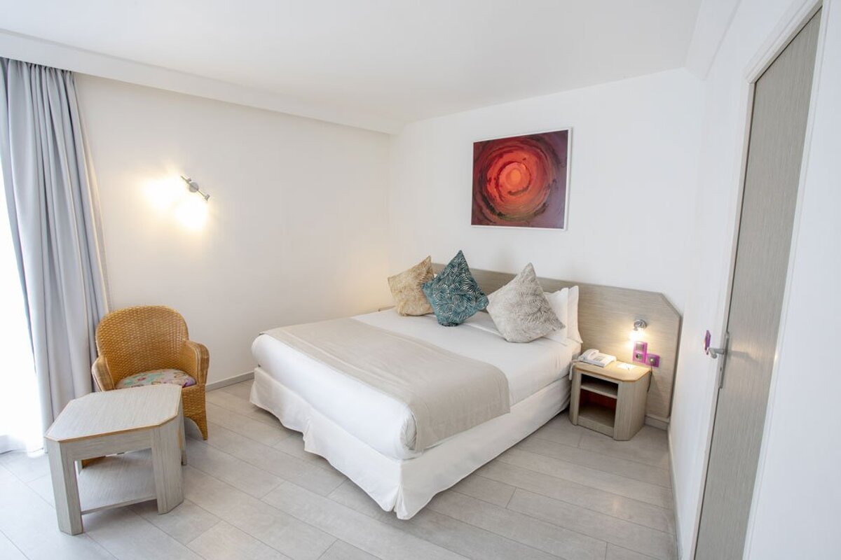 A hotel room with a large bed and a chair