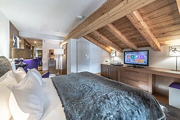 A bedroom with a large bed and a flat screen tv