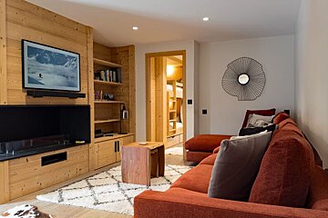 A living room with a red couch and a flat screen tv