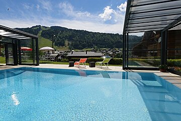 A swimming pool with chairs and umbrellas around it