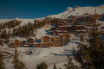 A ski resort with a lot of buildings covered in snow