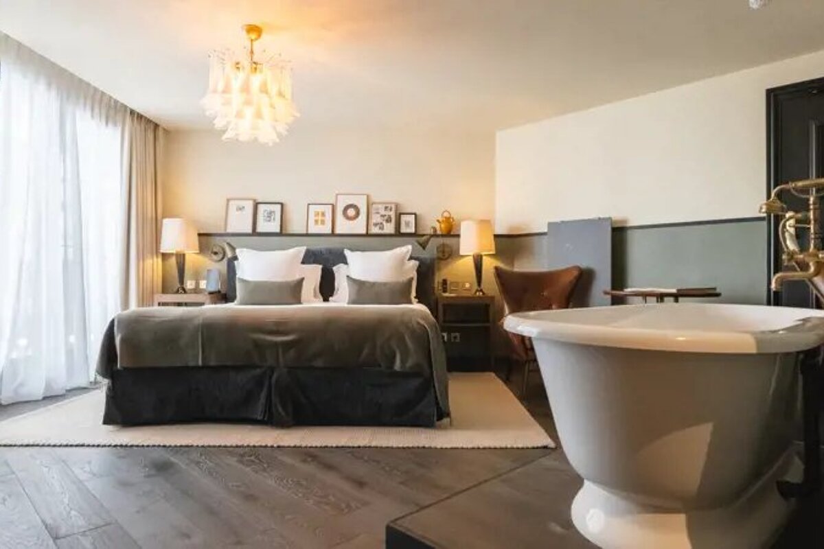 A hotel room with a large bed and a bathtub