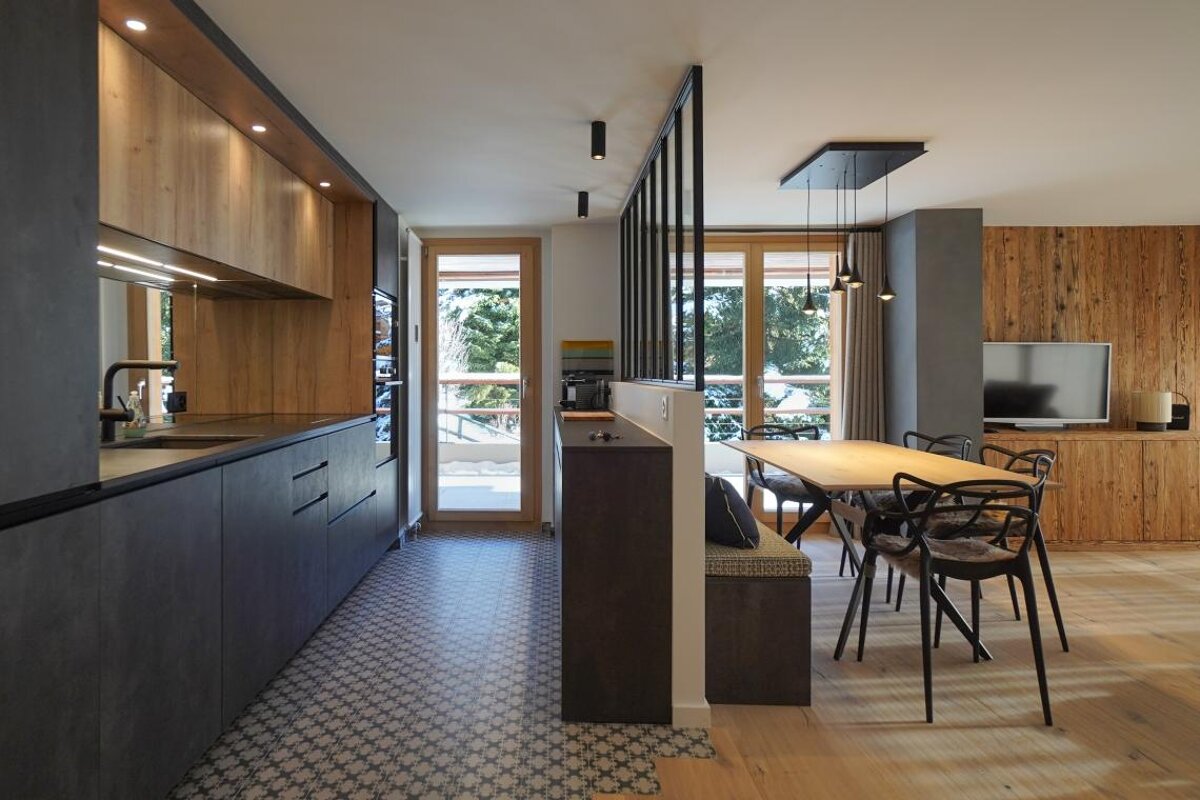 A kitchen with a table and chairs and a television