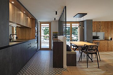 A kitchen with a table and chairs and a television