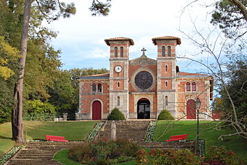 an orange colour church in lush green setting