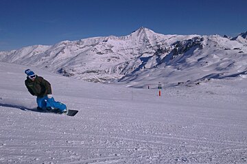 snowboarder on piste blue skies