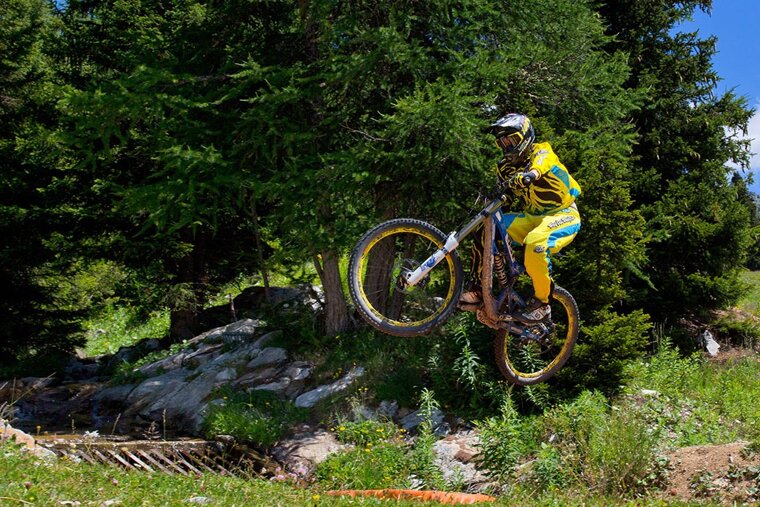 a mountain biker jumping over a river