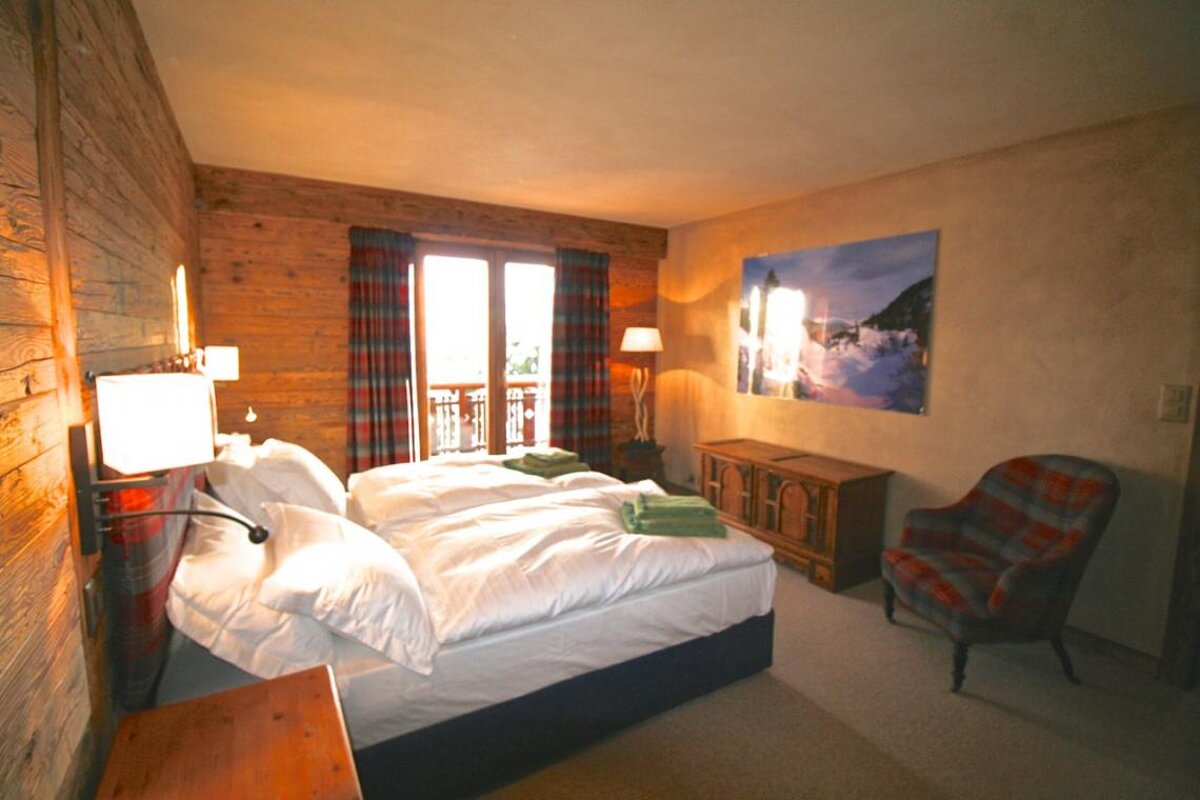 A bedroom with two beds and a picture on the wall