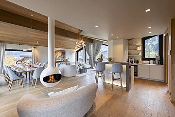 A living room with a fireplace hanging from the ceiling
