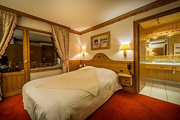 A hotel room with a single bed and a bathroom