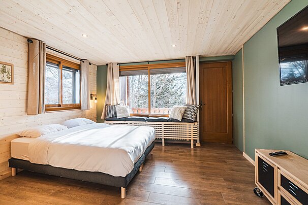 A bedroom with a large bed and a flat screen tv