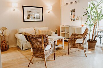 A living room with two wicker chairs and a couch