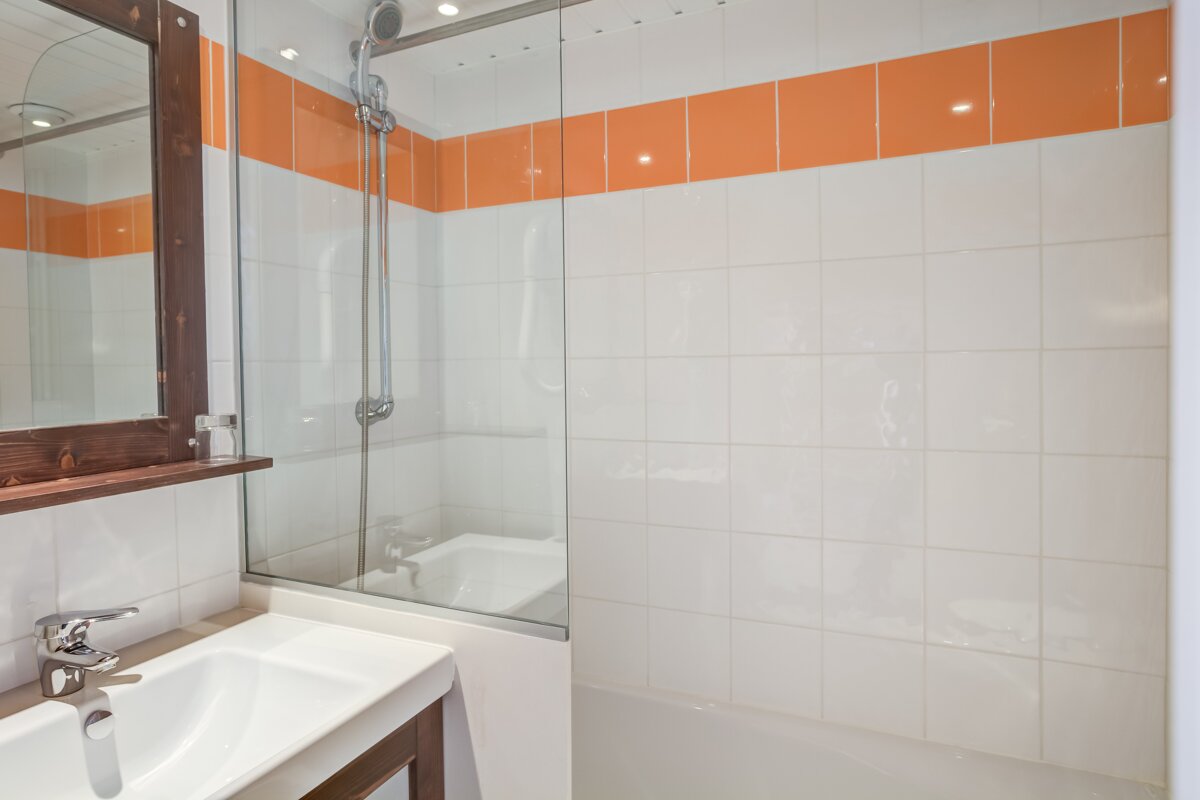 A bathroom with orange and white tiles and a sink
