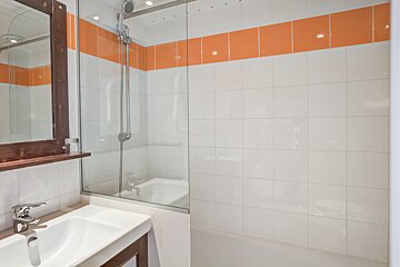 A bathroom with orange and white tiles and a sink
