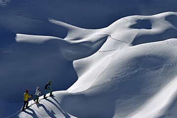 three people ski touring