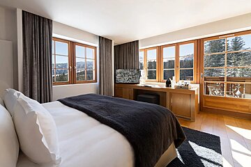 A hotel room with a large bed and a television