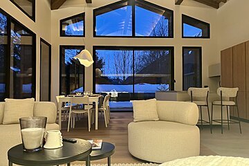 A living room with a lot of windows and a chair
