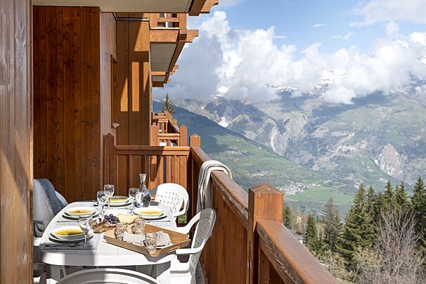 A balcony with a view of mountains and trees