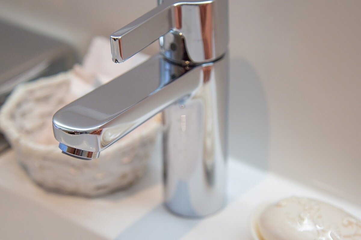 A bathroom sink with a chrome faucet and a soap dish