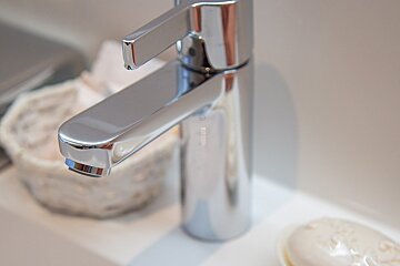 A bathroom sink with a chrome faucet and a soap dish