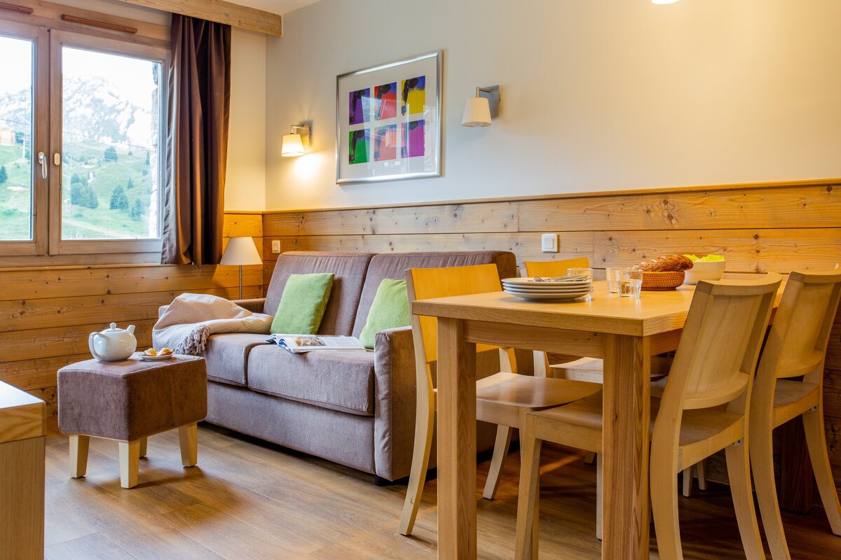 A living room with a couch a table and chairs