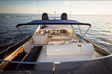 A boat with a steering wheel is floating in the ocean