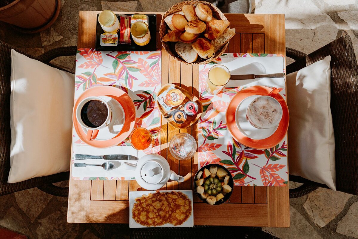A table topped with a variety of food and drinks including a tray of croissants