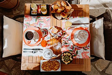 A table topped with a variety of food and drinks including a tray of croissants