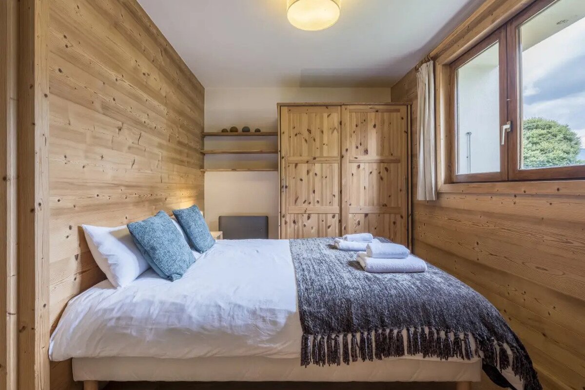 A bedroom with a king size bed and a window