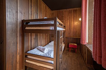 A bunk bed in a room with wood paneling