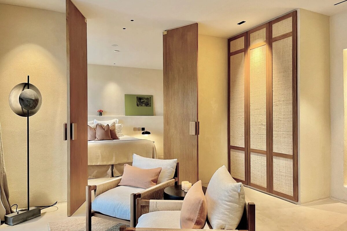 A bedroom with a chair and a painting on the wall