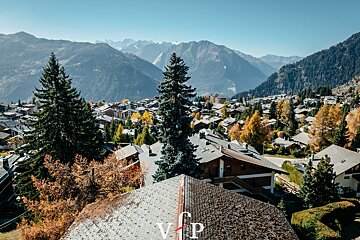 An aerial view of a village with mountains in the background