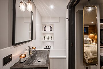 A bathroom with a sink a mirror and a bathtub