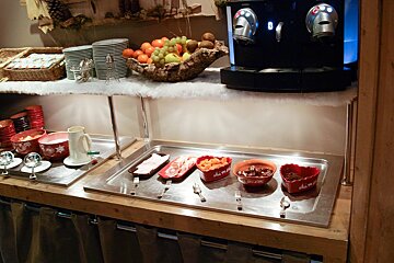 A buffet with bowls of food and a coffee machine
