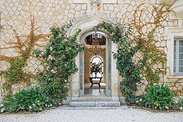 A doorway with flowers and a chandelier in the background