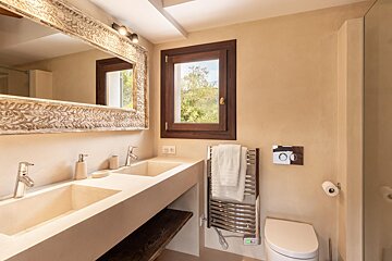 A bathroom with two sinks and a toilet
