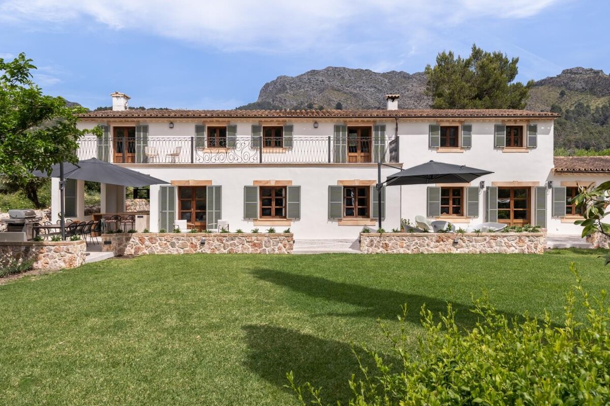 A large white house with mountains in the background