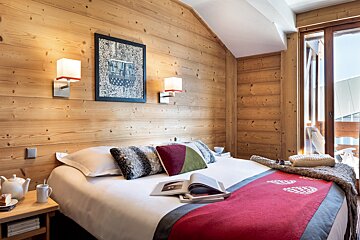 A bedroom with a bed and a picture on the wall