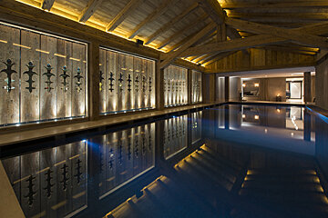 A large indoor swimming pool with a wooden roof