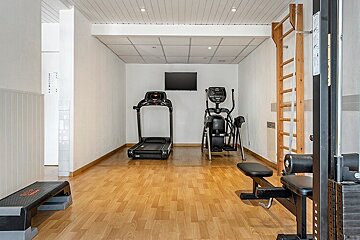 A gym with a treadmill and an elliptical