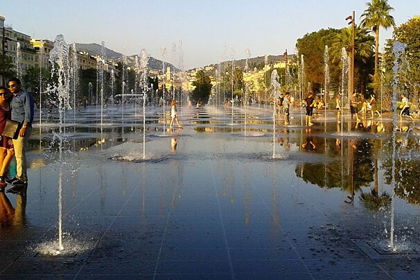 people walking through a fountain in the centre of Nice
