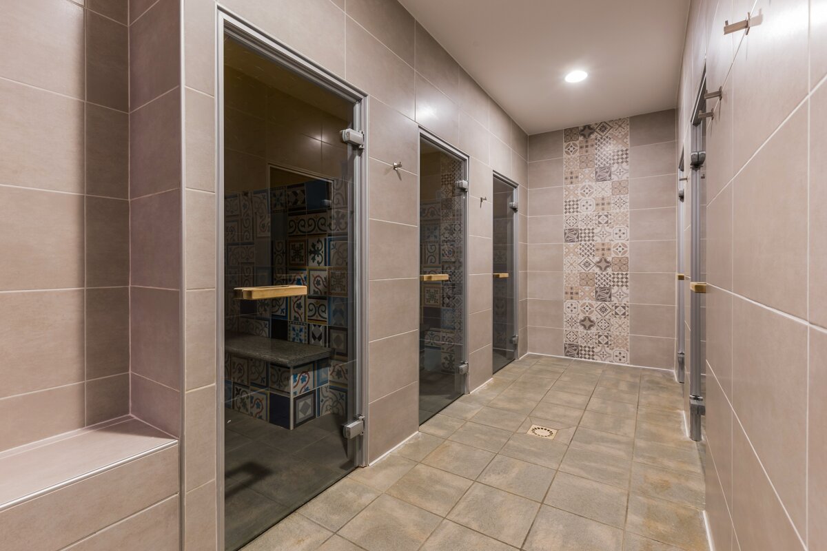 A bathroom with tiled walls and a drain in the floor